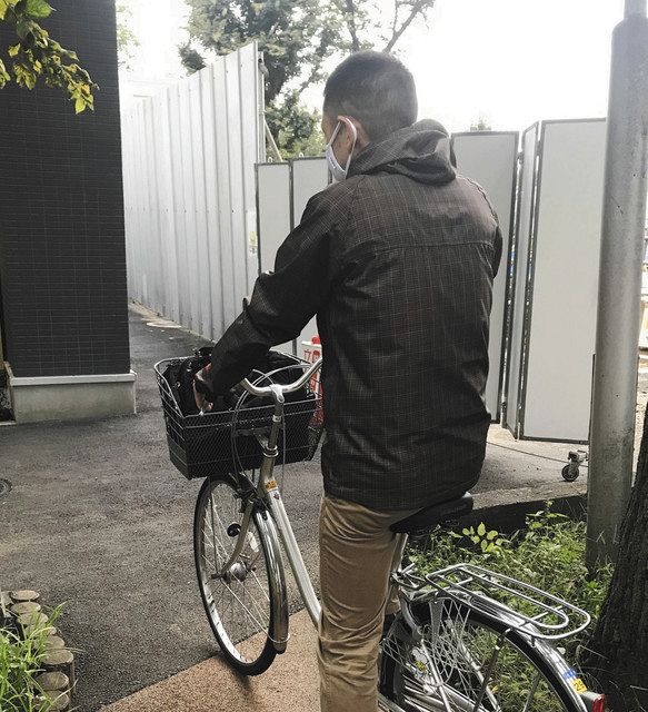 自転車で生活保護世帯を訪問するケースワーカー＝三鷹市で 