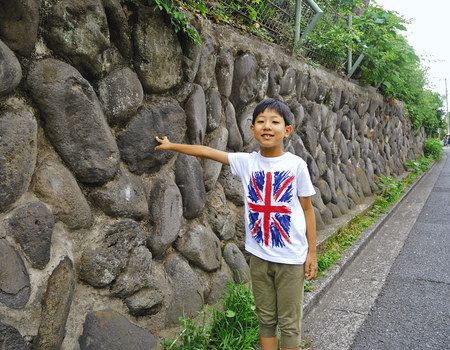 石垣の前に立ち、「大好きな壁を残して」と話す落合晴寿さん