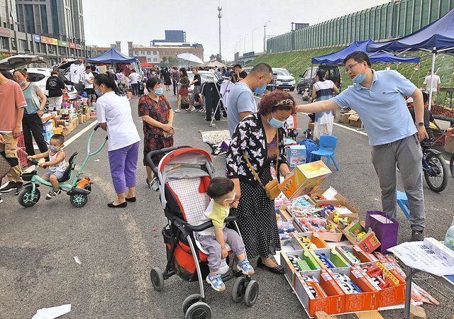河北省廊坊市で、道路上に商品を並べ売る出店者ら＝坪井千隼撮影