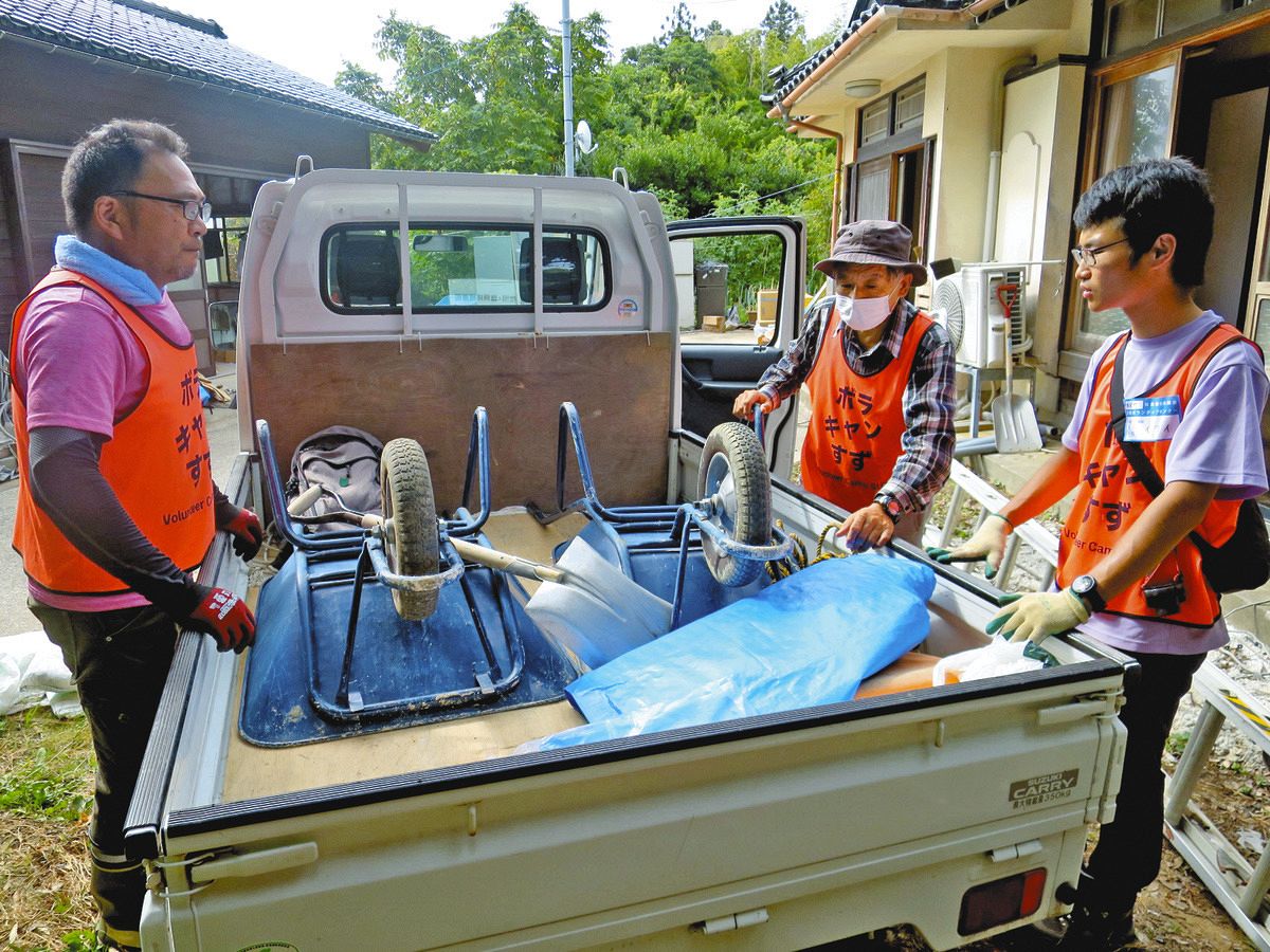 がれき撤去のため軽トラックから一輪車を運び出そうとするボランティア参加者＝8月、石川県珠洲市三崎町で