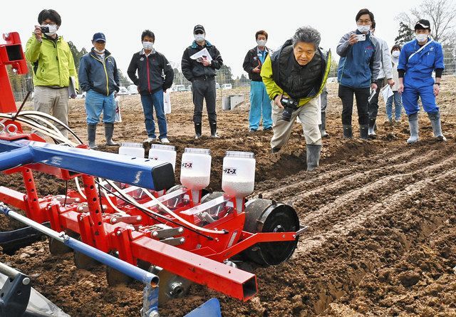 種をまく機械を見学する農家ら＝福島県浪江町で