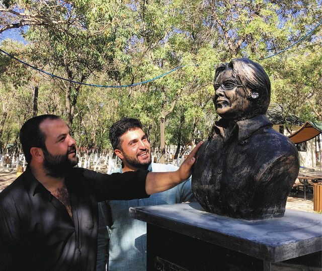 ８月末、トルコ東部ワンで、宮崎さんの胸像に触れるオルハンさん（右）とイルハンさん