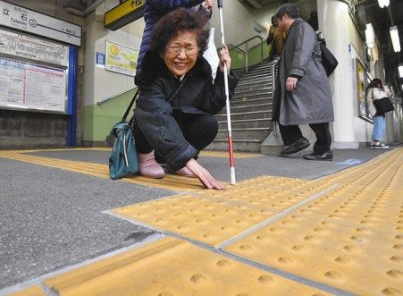 転落事故現場周辺で、張り替えられた点状ブロックを確認する古渡咲子さん＝葛飾区の京成立石駅で