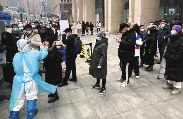 ２４日、北京市中心部のオフィスビル前で、ＰＣＲ検査の列に並ぶ人々＝中澤穣撮影 