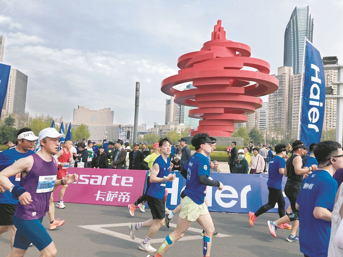 青島のランドマークモニュメント「5月の風」の前を走るランナーたち（新貝憲弘撮影）