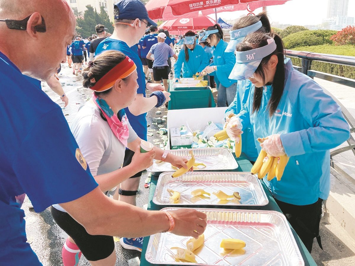 給水所で補給食のバナナを受け取るランナーたち（新貝憲弘撮影）
