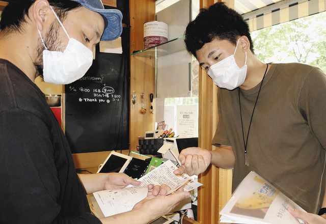 飲食店に「センキョ割」への参加を呼び掛ける今池陸晃さん（右）＝６月２６日、立川市で 