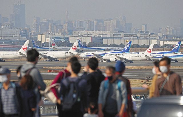 橋を渡る人ら。羽田空港が一望できる＝東京都大田区で