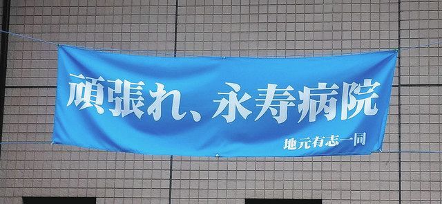 　病院の敷地内に掲げられている地元有志一同からの「頑張れ、永寿病院」の横断幕＝東京都台東区で