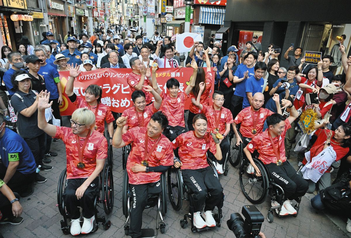 パレードで声援に応える池透暢主将（手前左から2人目）ら車いすラグビー日本代表のメンバー＝12日、東京都渋谷区で（七森祐也撮影）