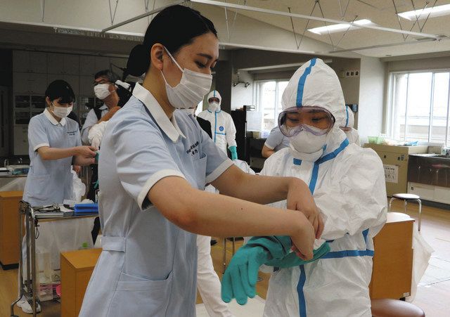 感染症防護服の着脱の方法を学ぶ看護学生ら＝幸区の市立看護短大で 