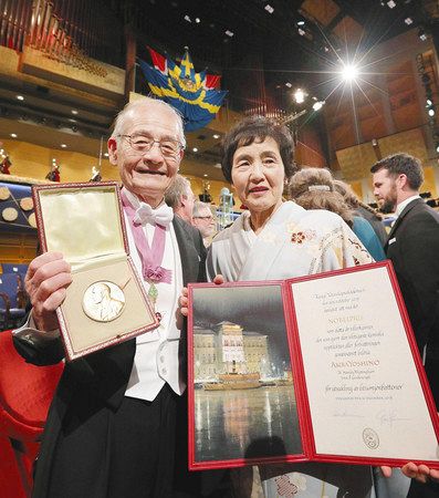 ノーベル化学賞のメダルを手に笑顔の吉野彰・旭化成名誉フェローと妻久美子さん＝１０日、ストックホルムのコンサートホールで（代表撮影・共同）