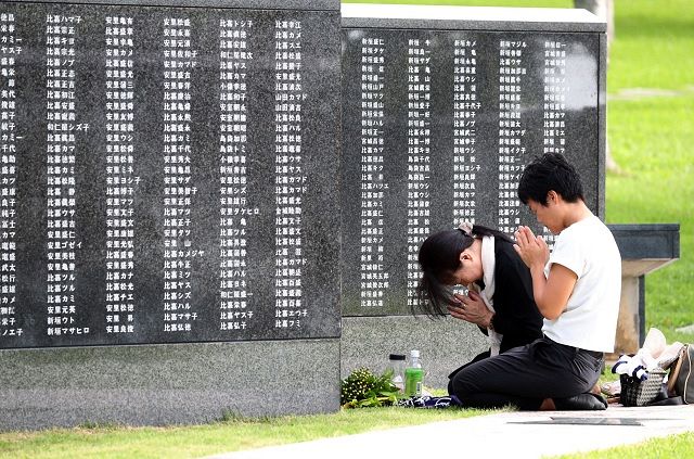 「平和の礎」の前で手を合わせる人々＝沖縄県糸満市の平和祈念公園で（2018年撮影）