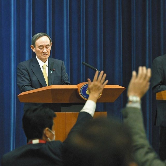 質問を求める記者の手が上がる中、打ち切られた菅首相の記者会見=13日、首相官邸で