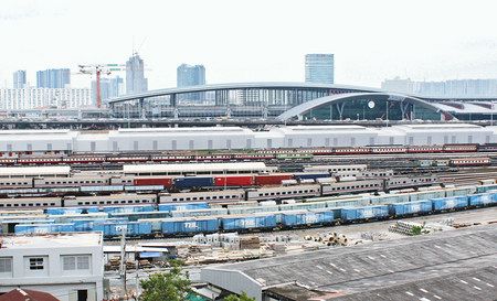 ２０２１年開業を目指して建設が進む、アーチ形の屋根が特徴のバンスー中央駅。手前は車両基地＝２日