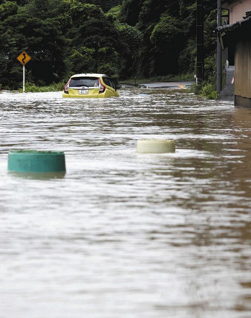 水に漬かった道路で立ち往生する車＝熊本県八代市で