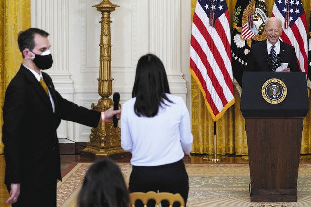 ３月２５日、米ホワイトハウスで開かれた就任後初の記者会見で、記者からの質問に応じるバイデン大統領（右）＝ＡＰ
