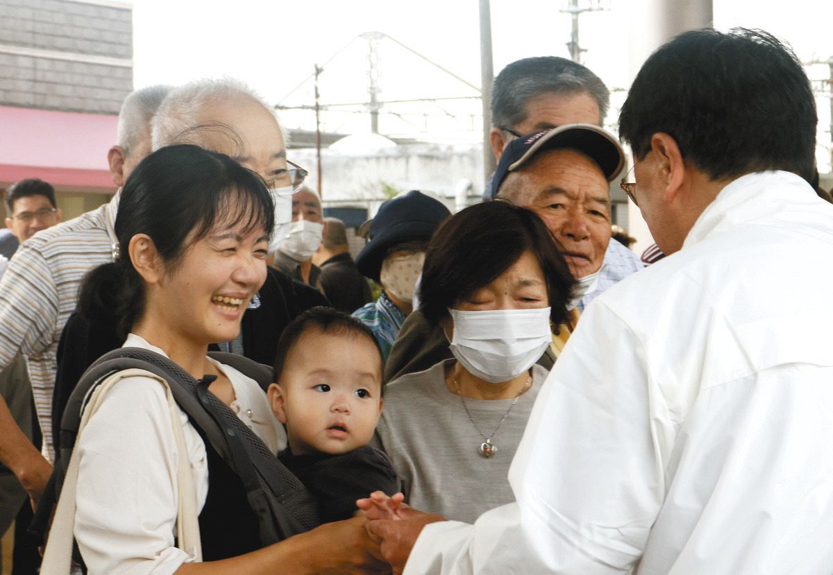 街頭演説後に支援者と握手する候補者（右）＝千葉県市原市で