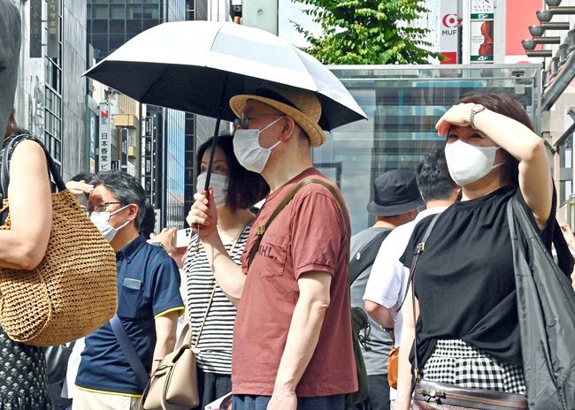 ［２日目、３６．２℃］　日傘や手で日差しをさえぎりながら、参院選候補者の訴えに耳を傾ける人たち＝26日、東京都中央区で、由木直子撮影