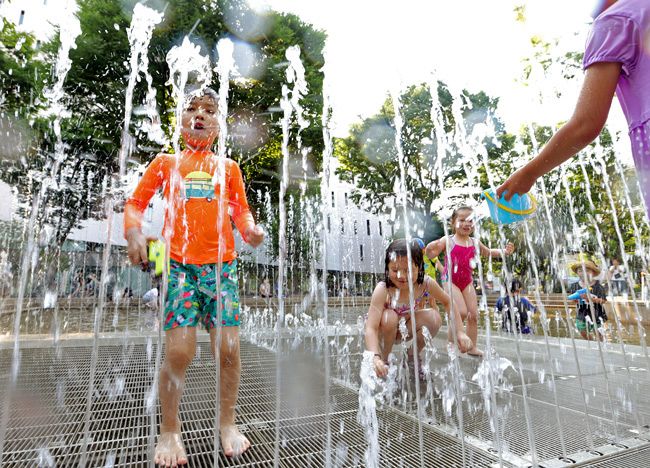 ［６日目、３６．４℃］　びしょ濡れになって水遊びを楽しむ子どもたち。36.4℃は東京都心の6月の観測史上最高＝30日、中野区で、佐藤哲紀撮影