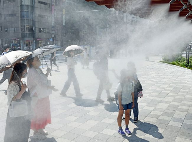 ［８日目、３５．２℃］　ドライミストに足を止める人たち＝2日、中央区で、安江実撮影