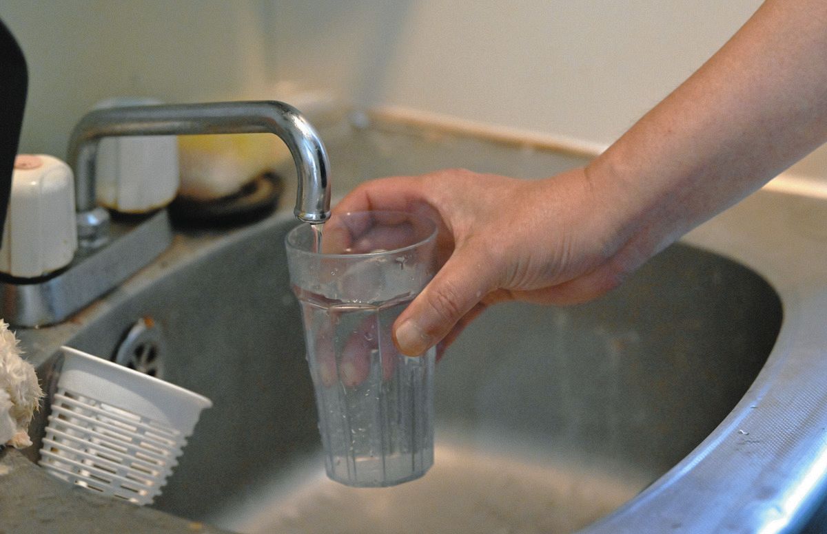 水道の水をくむ男性=東京都内で