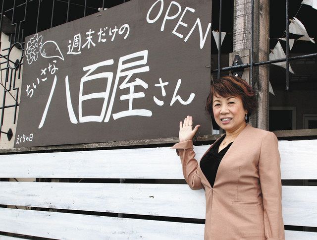 看板の前で「これからも工夫して野菜販売を続けたい」と話す山本恵さん＝水戸市元吉田町で 