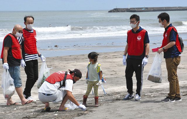 サーフィンの競技会場となる釣ケ崎海岸で清掃活動に取り組む社員らＪＡＬグランドサービスの社員ら＝一宮町で
