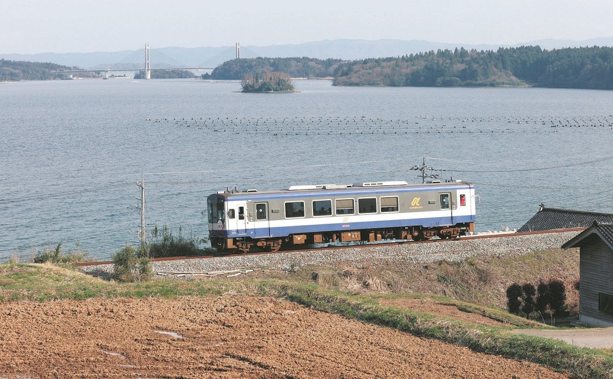 のと鉄道七尾線が全線開通し、海沿いを走る列車＝6日、石川県七尾市で
