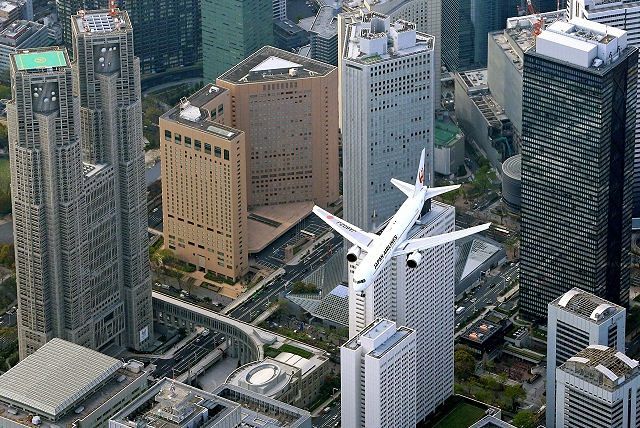 都心上空の羽田新ルートを飛ぶ旅客機。左は東京都庁=本社ヘリ「おおづる」から（2020年9月）