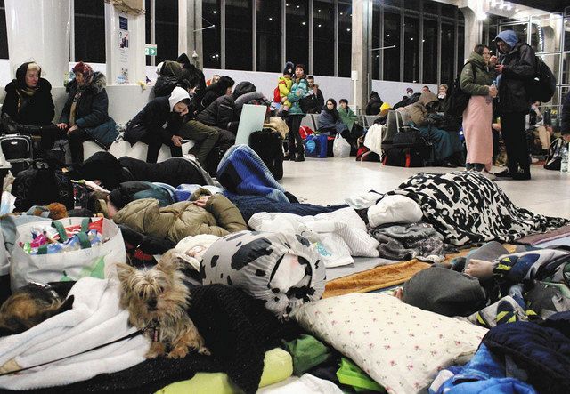 10日未明、ポーランドのワルシャワ中央駅で、いすや床に敷いた毛布の上で休息を取るウクライナ避難民ら