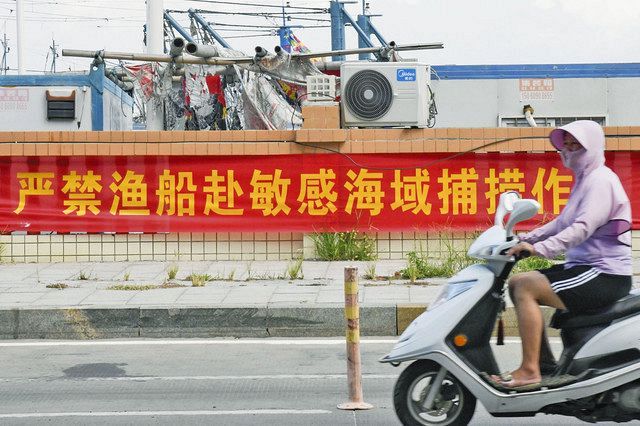 １５日、中国福建省泉州市で、漁港に掲げられた「漁船が敏感な海域に行って漁をするのは厳禁」と書かれた横断幕＝共同