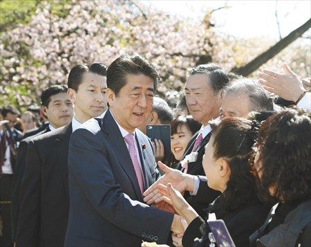 「桜を見る会」で招待客と握手する安倍首相＝昨年４月、東京都新宿区で