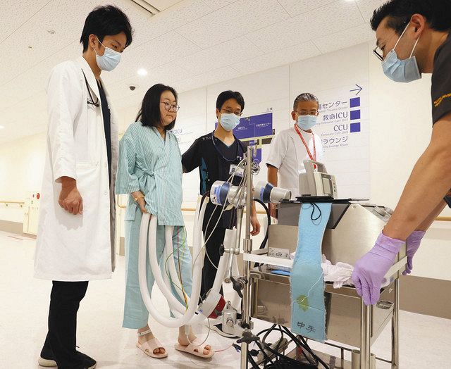 病院スタッフとリハビリをする中国人女性（左から２人目）。中国・武漢での心臓移植手術を控え、体外式の人工心臓につながれている＝１日、愛知県豊明市の藤田医科大病院で（内山田正夫撮影）
