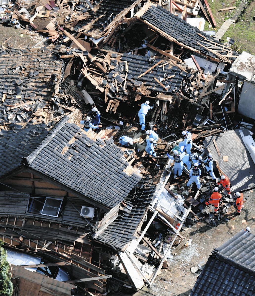 倒壊した民家で行方不明者の捜索をする消防隊員ら＝5日、石川県輪島市で、本社ヘリ「あさづる」から