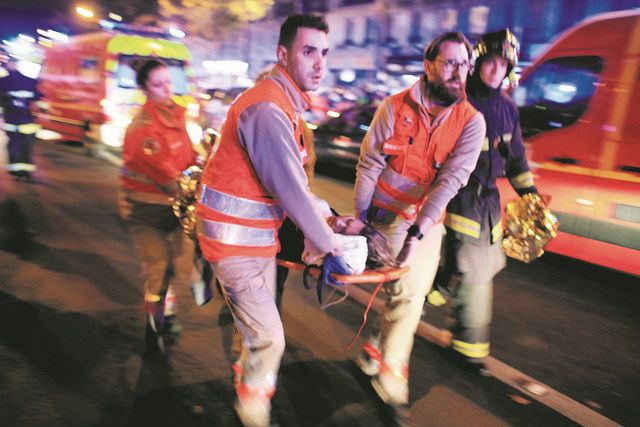 ﻿2015年11月13日、パリのバタクラン劇場から担架で女性を運ぶ救助隊員＝AP
