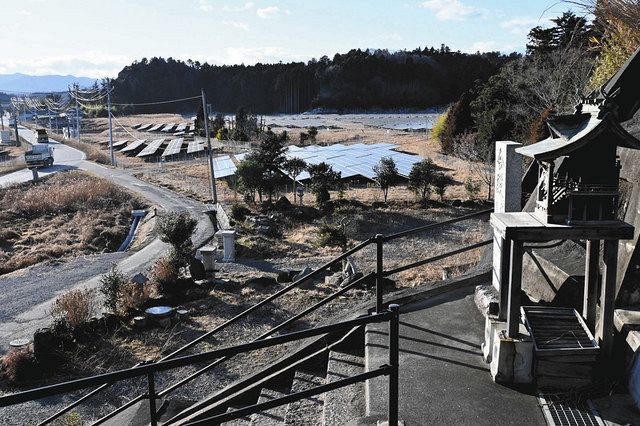 震災当時、４０人ほどが津波から逃れた諏訪神社境内への階段踊り場にある社。奥には太陽光発電所が広がっていた＝福島県双葉町で