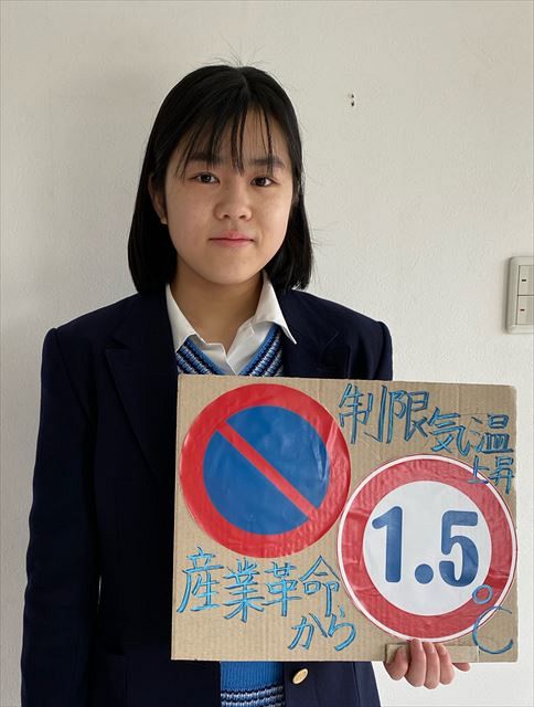 道路標識と絡めて気候変動対策を訴えるFridays For Future Japanのメンバー（提供写真）