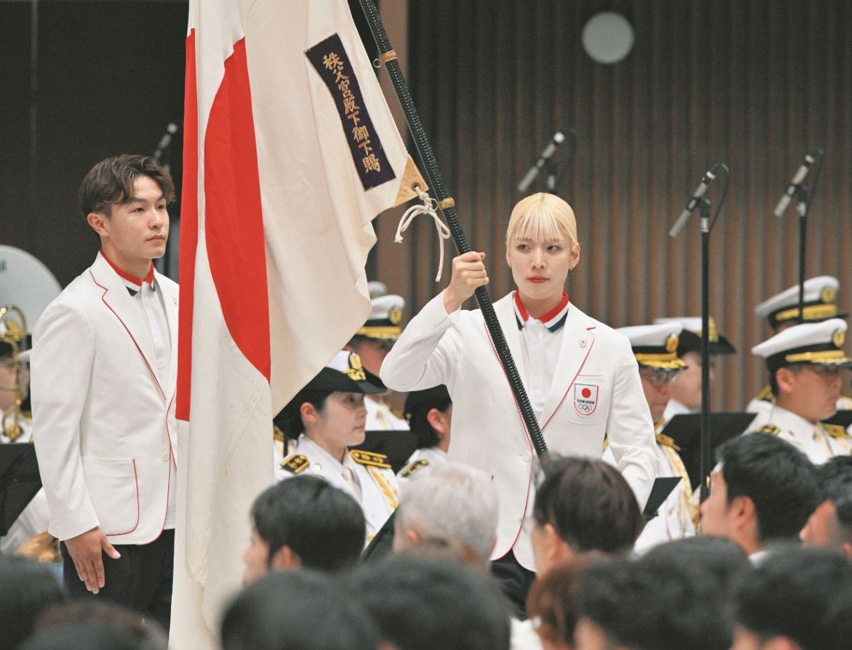 5日、パリ五輪結団式で団旗を手にするフェンシングの江村美咲選手（右）とブレイキンの半井重幸選手