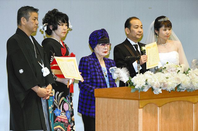 結婚式を挙げた夫婦２組と記念撮影をする桂由美さん（中）＝葛飾区で 