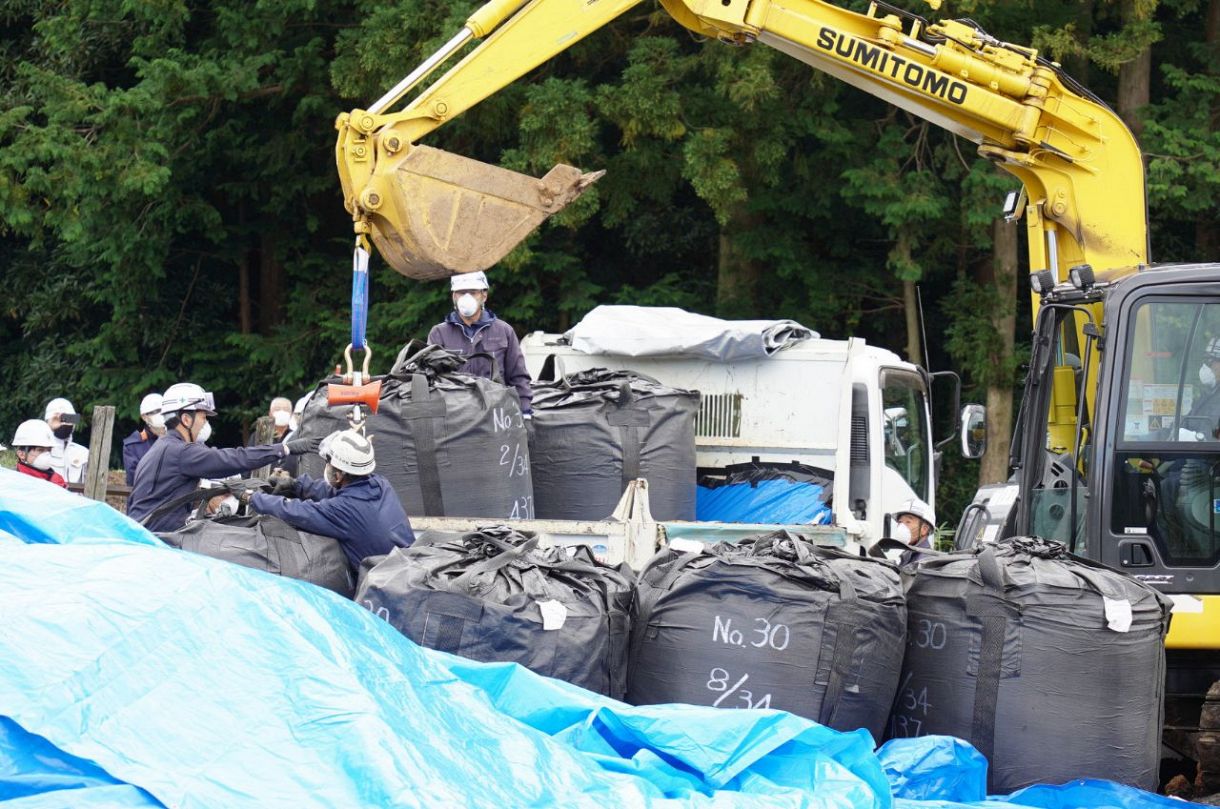 重機で指定廃棄物をトラックに積み込む作業員＝栃木県那須塩原市で