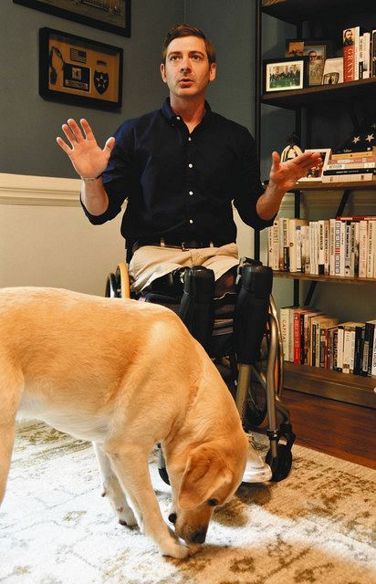 米南部ジョージア州で８月１６日、アフガン戦争について語るダン・ベルシンスキーさん。手前は介助犬のバンス