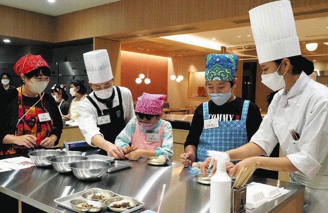 作り方を教わりながら家族で里芋料理に挑戦する参加者＝新宿区の新宿調理師専門学校で