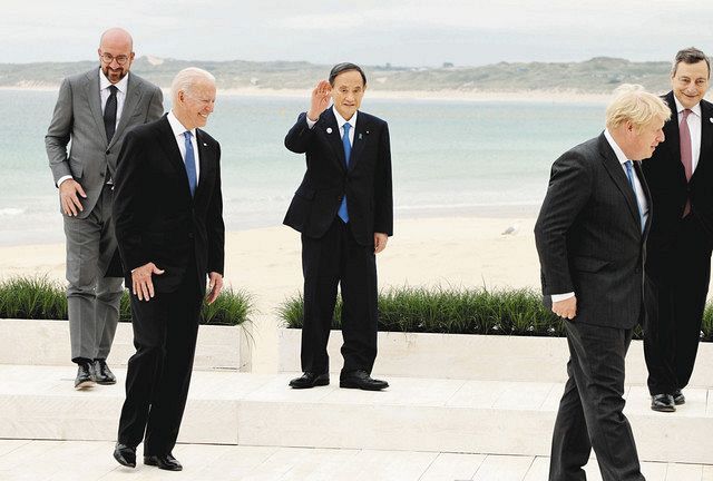 G7サミットの記念撮影を終え手を振る菅首相(中央)。前列左はバイデン米大統領、同右は英国のジョンソン首相=11日、英コーンウォール(代表撮影)