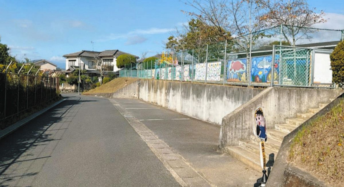 左側は、全国最多の弾薬庫9棟が新設予定の大分分屯地のフェンス。道を挟んだ向かい側に保育所がある