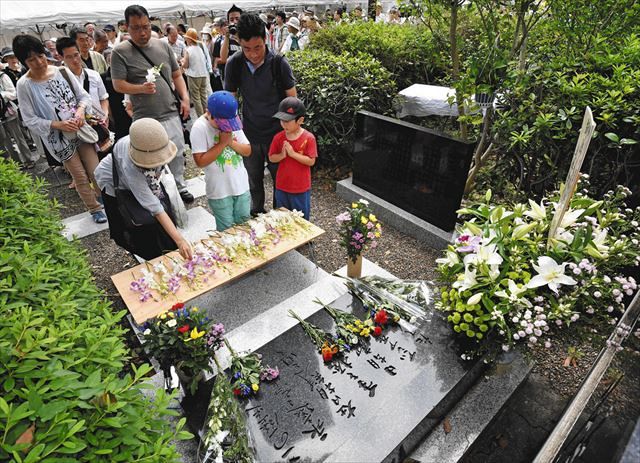 関東大震災の朝鮮人犠牲者の追悼碑に献花し、手を合わせる人たち＝２０１９年９月１日、東京都墨田区の横網町公園で
