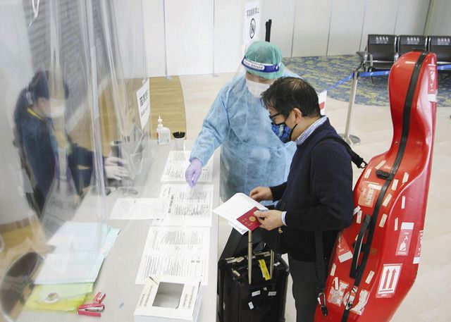 新型コロナウイルスの変異種発生を受け、欧州から到着した旅客に防護服で対応する検疫担当の職員＝２０２０年１２月、成田空港
