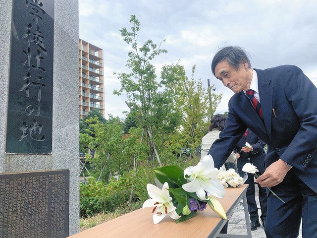 「出陣学徒壮行の地」の碑の前に花を供える関係者＝新宿区で