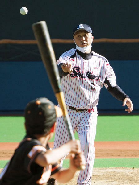 [photo]　参加選手を相手に、打撃投手を務める宮本大会会長