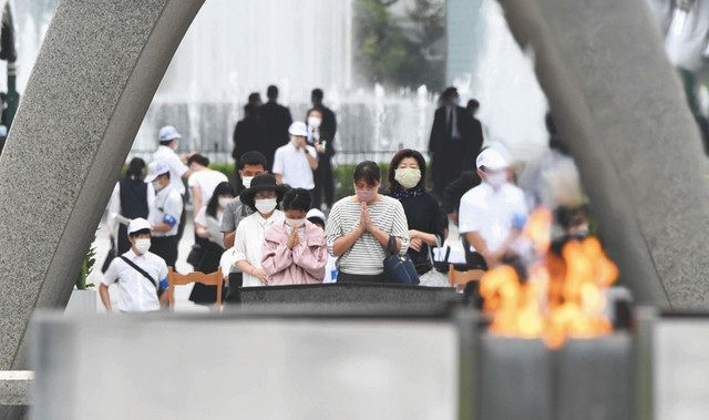 原爆慰霊碑の前で手を合わせる人たち＝８月６日、広島市の平和記念公園で
